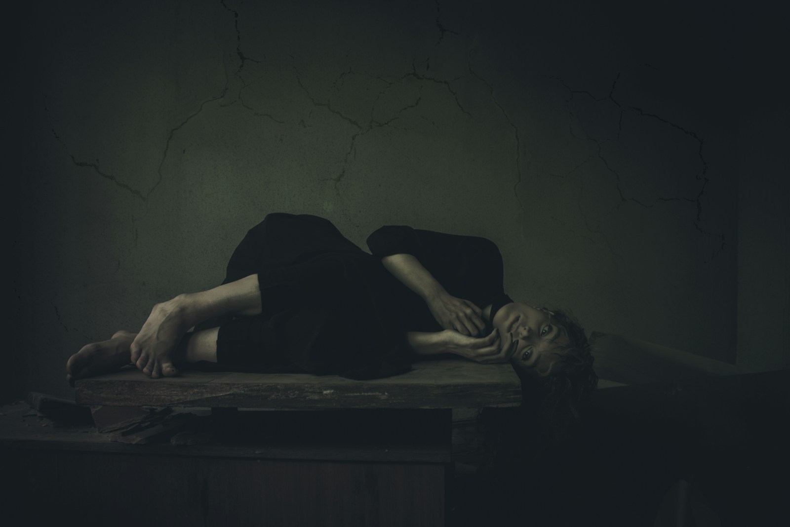 a woman laying on a table in a dark room