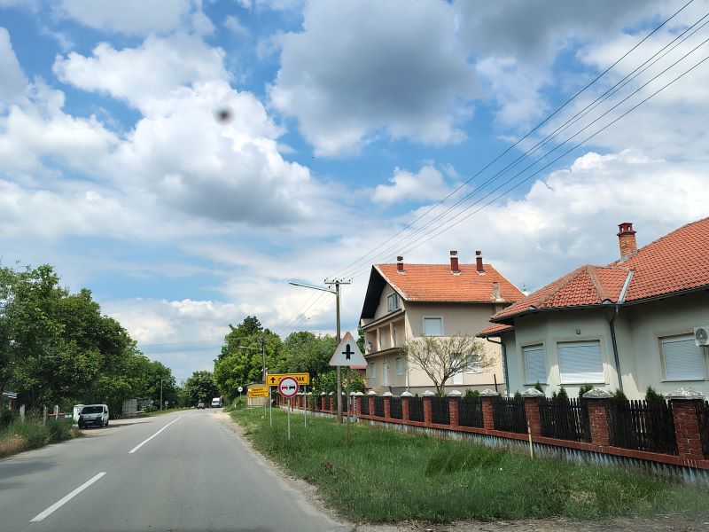 ulica u naseljenom mestu po sunčanom i toplom vremenu tokom junskog dana u Srbiji.